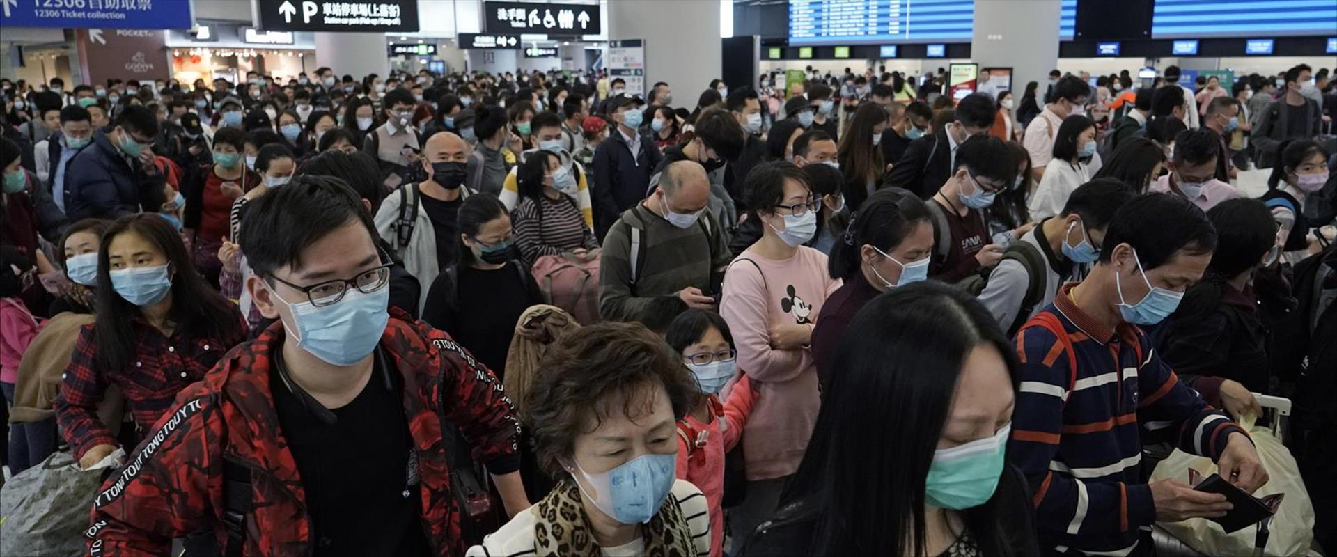 נוסעים לובשים מסכות הגנה בתחנת רכבת בהונג קונג